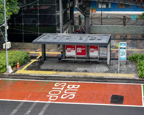 Seseorang menunggu di halte saat cuaca cerah di Jakarta